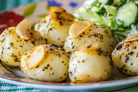 Baby potatoes and garlic fried in melted butter ghee with spices, salad cabbage and cucumbers. Healthy Vegetarian Foodの写真素材