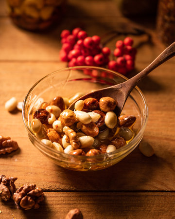 Top view of round bowl with Honey mixed with nuts. rowan berries and peeled walnuts. Still life photographyの写真素材