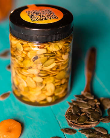 Pumpkin seeds and honey in jars on wooden blue color table in Rustic style. Autumn Season food photo.の写真素材