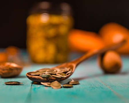 Pumpkin seeds and honey in jars on wooden blue color table in Rustic style. Autumn Season food photo.の写真素材