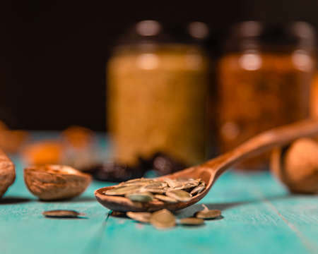 Pumpkin seeds and honey in jars on wooden blue color table in Rustic style. Autumn Season food photo.の写真素材