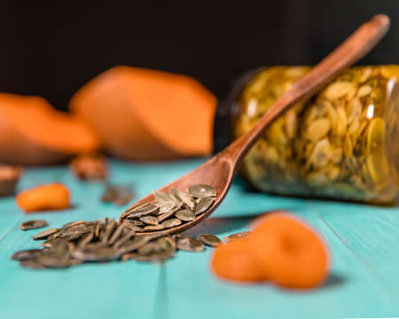 Pumpkin seeds and honey in jars on wooden blue color table in Rustic style. Autumn Season food photo.の写真素材