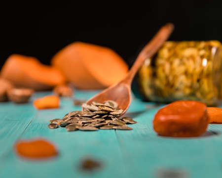Pumpkin seeds and honey in jars on wooden blue color table in Rustic style. Autumn Season food photo.の写真素材