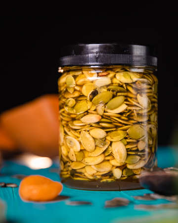 Pumpkin seeds and honey on wooden blue color table in Rustic style. Autumn Season food photo.の写真素材