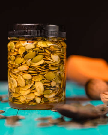 Pumpkin seeds and honey on wooden blue color table in Rustic style. Autumn Season food photo.の写真素材