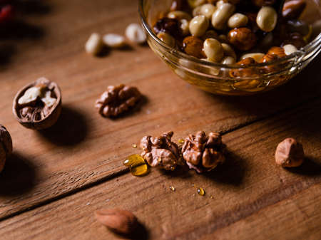 Top view of round bowl with Honey mixed with nuts on wooden table. Close up Still life photography.の写真素材