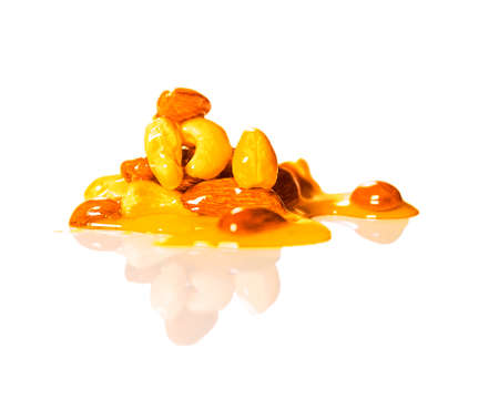 Pile or drops of honey mixed with nuts isolated on white background.の写真素材