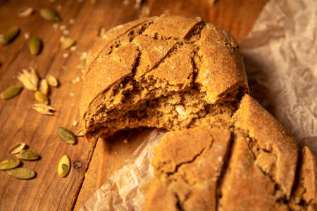 Made by hand fresh bread and wheat grains on on parchment paper the wooden table.の写真素材