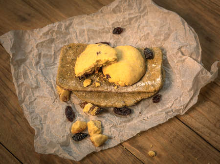 Made by hand fresh tortillas and cookies with raisins on parchment paper on wooden table. View from aboveの写真素材