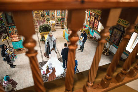 Pokrov, Ukraine - January 24, 2021: Church of St. John Chrysostom. Church wedding. Bride wearing a white dress and a veil from the back.のeditorial素材