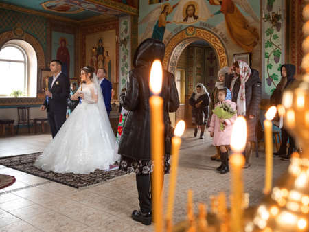 Pokrov, Ukraine - January 24, 2021: Church of St. John Chrysostom. Church wedding. Bride wearing a white dress and a veil from the back.のeditorial素材