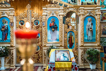 Pokrov, Ukraine - January 24, 2021:Church of St. John Chrysostom. Interior of an Orthodox Ukrainian church. Iconostasis, altar. Blurred burning candle.のeditorial素材