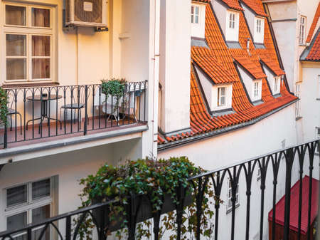 A view of typical Prague house with red tile roof. Balcony and plantsの写真素材