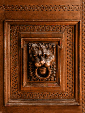 Prague, Czech Republic - April 2022: Fragment of wooden antique door of Old Town Hall or Staromestska Radnice with lion head.のeditorial素材