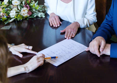 Middle aged retired couple signing marriage contract before wedding ceremony.の写真素材