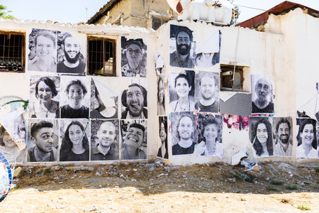Nicosia, Northern Cyprus - June 28, 2022: Black and white photographs of people on the wall of a building on a city streetのeditorial素材