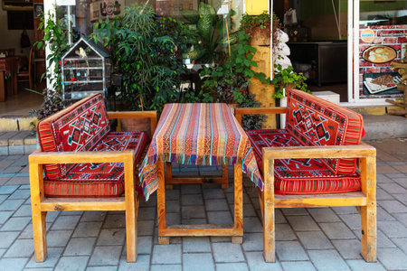 Nicosia, Northern Cyprus - June 28, 2022: Table and sofas with traditional folk ornament in a street cafeのeditorial素材