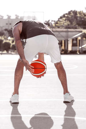 A man shows a basketball technique passing the ball between the legs.の写真素材