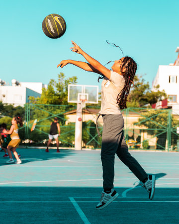 Northen Cyprus, Girne, Alsancak - Jule, 25, 2023: Basketball sport training on a basketball court in summer. Portrait of 12-yars old girl jumping and shooting ball.のeditorial素材
