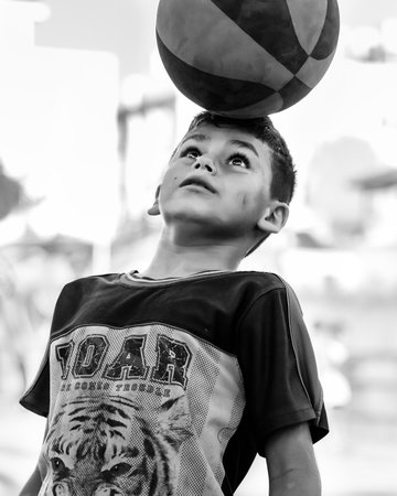 Northen Cyprus, Girne, Alsancak - Jule, 25, 2023: 10 year old boy playing with a ball with his head outside.のeditorial素材