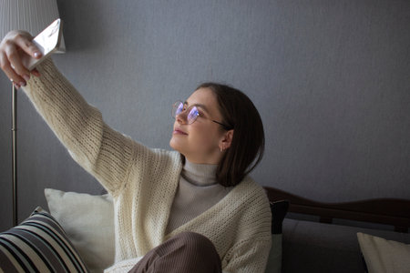 Smiling young woman taking a selfie with smartphoneの写真素材