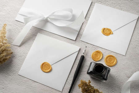 High angle of wedding paper and envelope with ink and pen