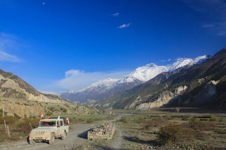 mountains and white clouds and blue sky, car on the roadの写真素材