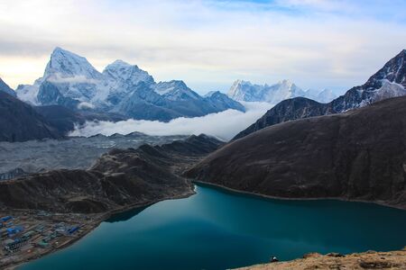 snow mountains against white clouds and blue sky, lakeの写真素材