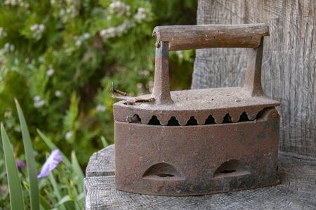 Old metal rusty vintage iron on coals.The old device for Ironing clothesの写真素材