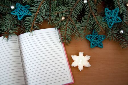 Christmas tree branches, cones, hearts, stars, a notebook on a wooden texture.の写真素材