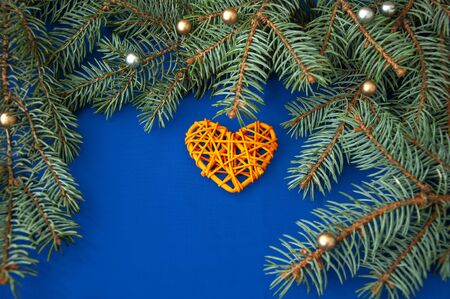 Christmas tree branches, balls, hearts, gift on a blue backgroundの写真素材