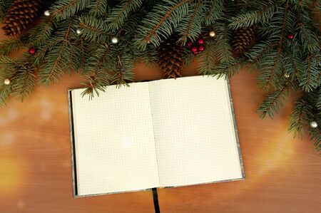 Christmas tree branches, cones, hearts, stars, a notebook on a wooden texture.の写真素材
