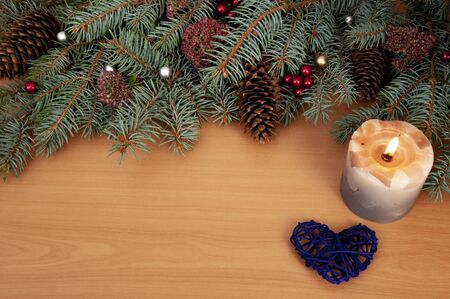 Christmas background. Christmas tree branches, gift, hearts, balls, candle and stars on wooden textureの写真素材