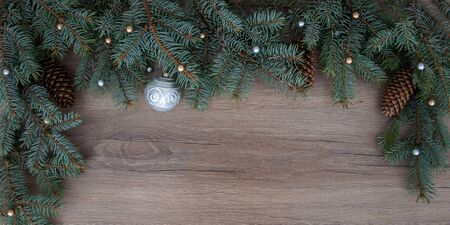 Christmas branches, cones, decorations on a wooden texture. Holiday Christmas backgroundの写真素材
