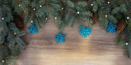 Christmas branches, cones, decorations on a wooden texture. Holiday Christmas backgroundの写真素材
