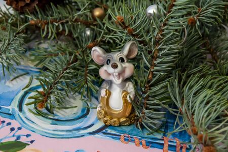 Christmas rat on the background of Christmas tree branches of red and silver balls.の写真素材