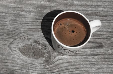 Beige cup of coffee on a wooden background