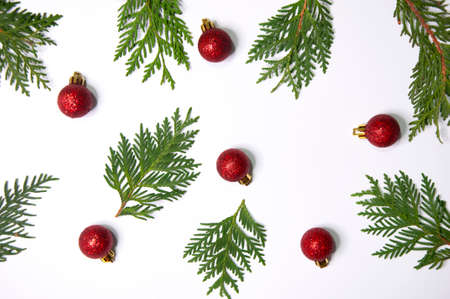 Thuja twigs and christmas red balls on a white backgroundの写真素材
