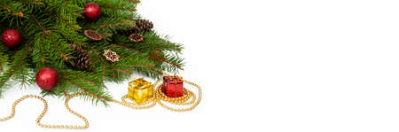 Branches of a Christmas tree and red and yellow gift boxes and balls on a white background. Christmas background with copyspaceの写真素材