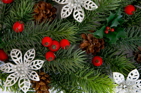 Decorated branches of a Christmas tree, cones, red berries on a wooden background. Christmas decor.の写真素材