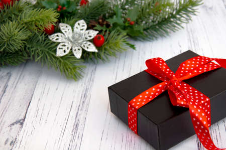 Decorated branches of a Christmas tree, cones, red berries and gifts on a wooden table. Christmas decor.の写真素材
