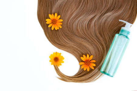 Cosmetic for hair and flowers for hair on a white background. Healthy and beautiful hair. Hair care. Copy space for textの写真素材