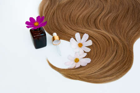 Cosmetic for hair and flowers for hair on a white background. Healthy and beautiful hair. Hair care. Copy space for textの写真素材