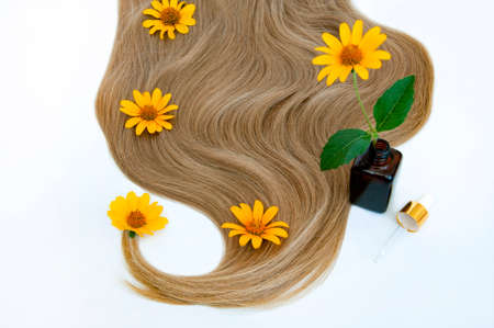 Cosmetic for hair and flowers for hair on a white background. Healthy and beautiful hair. Hair care. Copy space for textの写真素材