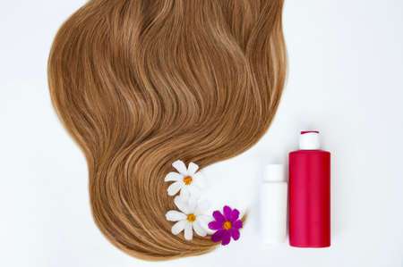 Cosmetic for hair and flowers for hair on a white background. Healthy and beautiful hair. Hair care. Copy space for textの写真素材