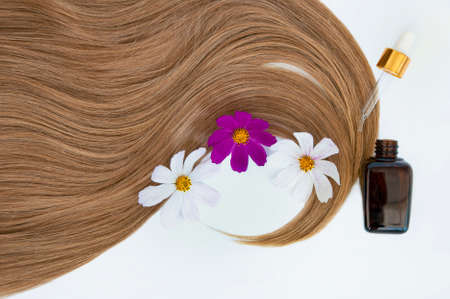 Cosmetic for hair and flowers for hair on a white background. Healthy and beautiful hair. Hair care. Copy space for textの写真素材
