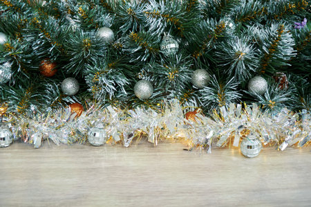 Christmas background with Christmas tree branches, blue and yellow layers and silver tinsel on a wooden background. Copy space for textの写真素材