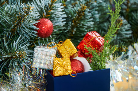 Christmas composition with Christmas tree branches, red tinsel, gift boxes and silver tinselの写真素材