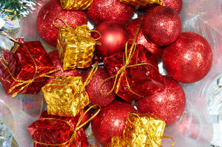 Christmas composition with red balls on yellow gifts in silver tinselの写真素材