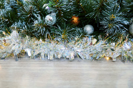Christmas background with Christmas tree branches, blue and yellow layers and silver tinsel on a wooden background. Copy space for textの写真素材